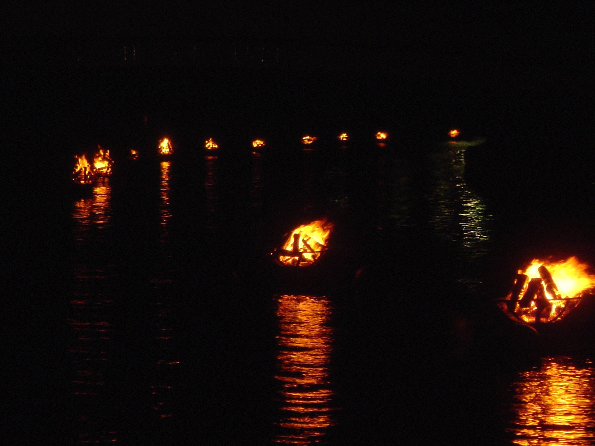 WaterFire braziers lit along the Providence River at night